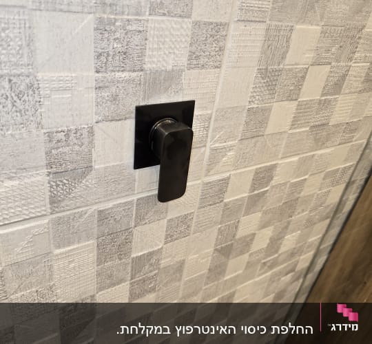 ידית ברז על קיר אריחים מעוצב